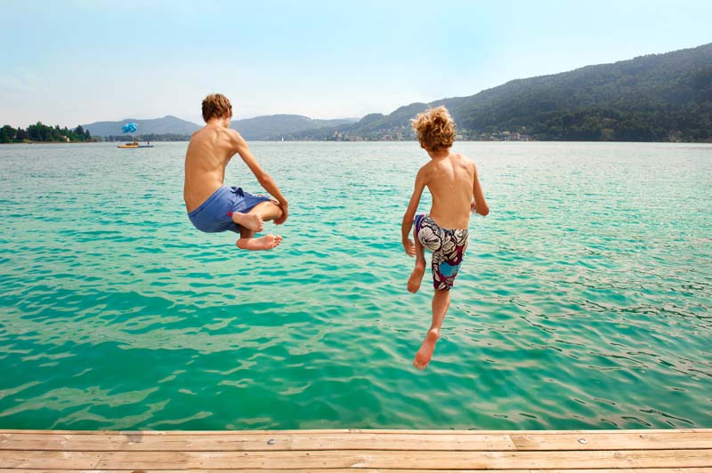 2 Kinder springen vom Steg ins Wasser