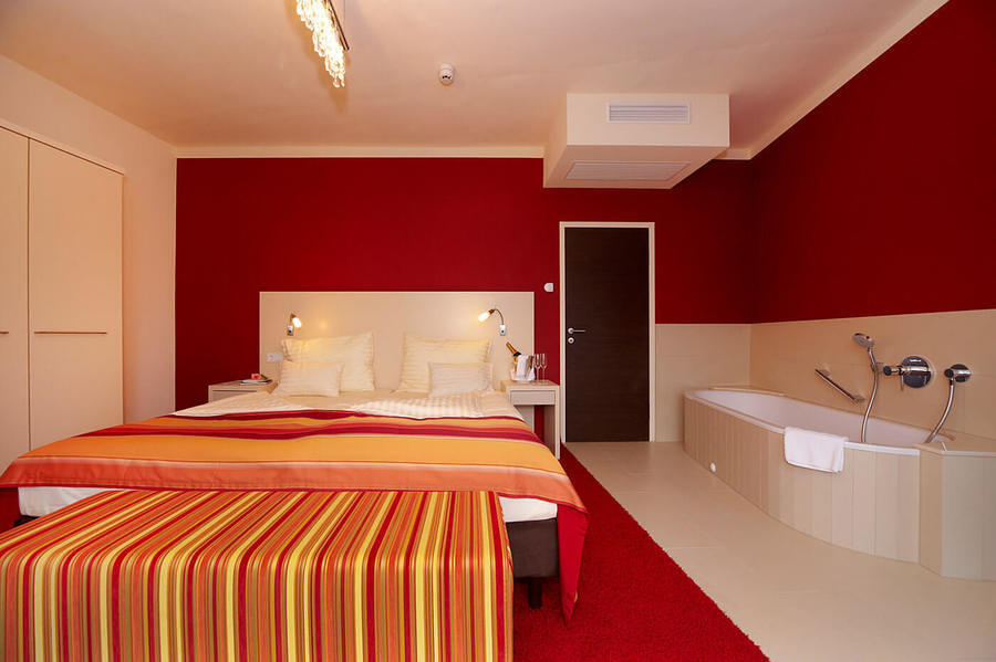 Seesuite mit Doppelbett und Badewanne im Zimmer