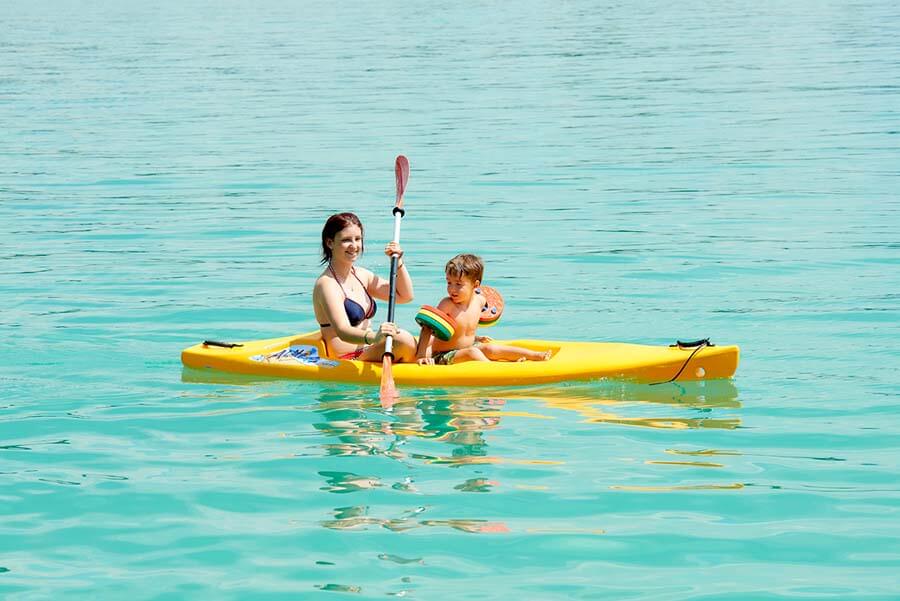 Frau mit Kind in einem Kanu am See