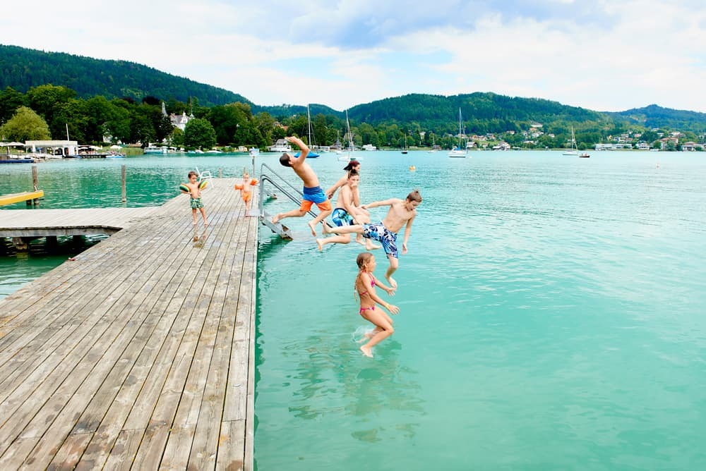 Kinder springen vom Steg ins Wasser