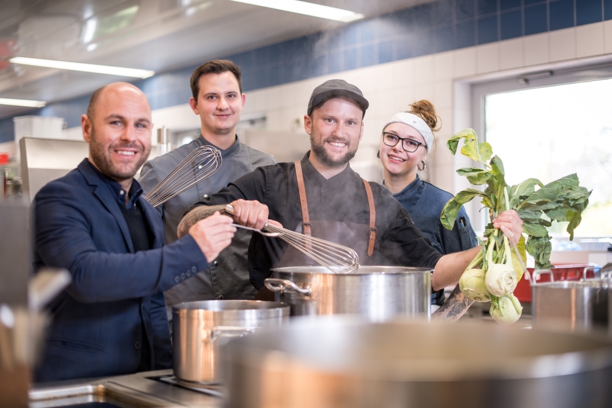 Hoteldirektor mit Küchenchef und Lehrlingen 