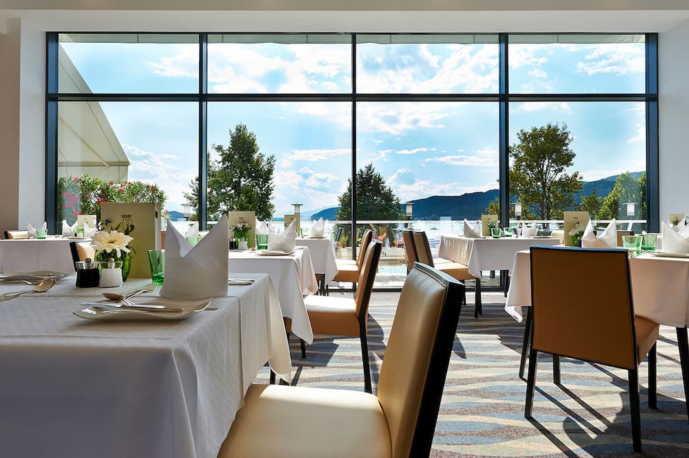 Hotelrestaurant mit gedeckten Tischen und Seeblick