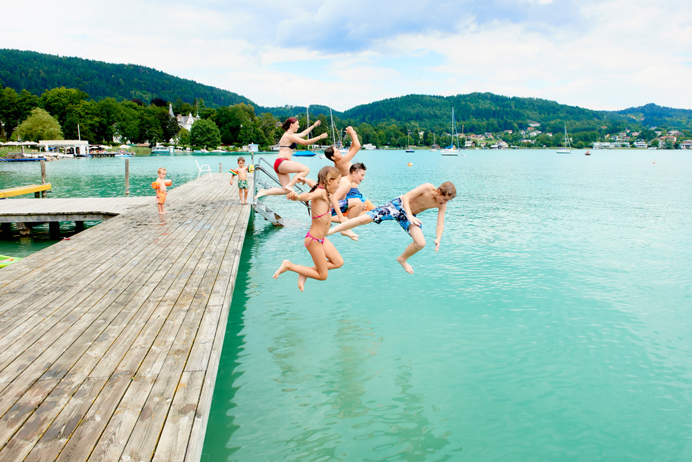 Kinder springen vom Steg in den Wörthersee