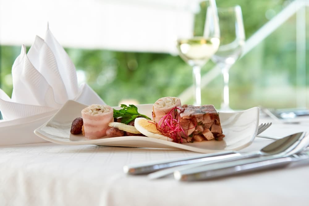 regionale Kulinarik auf einen gedeckten Tisch im Hotelrestaurant des Parkhotel Pörtschach